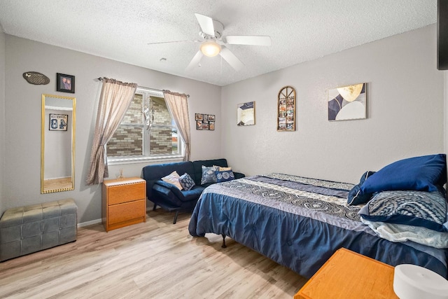 bedroom featuring ceiling fan, a textured ceiling, and light wood-type flooring