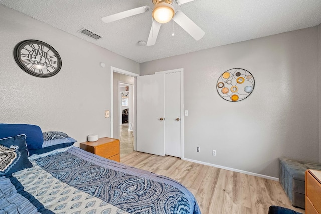 bedroom with wood-type flooring, ceiling fan, and a textured ceiling