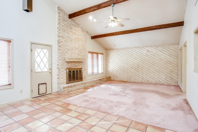 unfurnished living room featuring high vaulted ceiling, a wealth of natural light, a fireplace, and beam ceiling