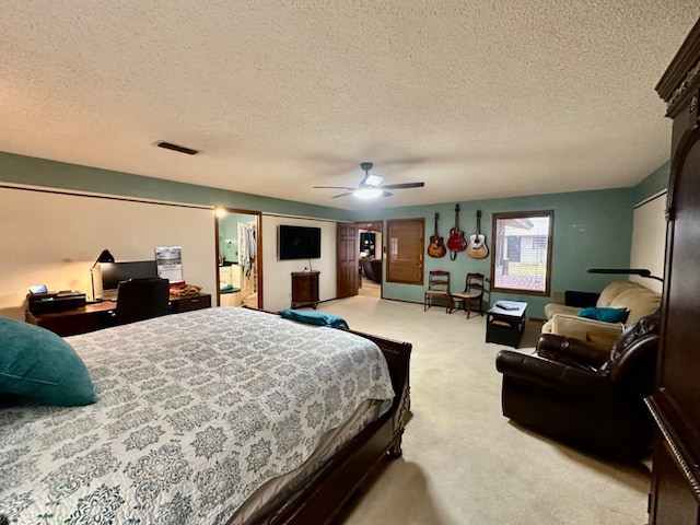 carpeted bedroom with ceiling fan and a textured ceiling