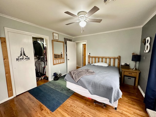 bedroom featuring crown molding, ceiling fan, hardwood / wood-style floors, and a closet