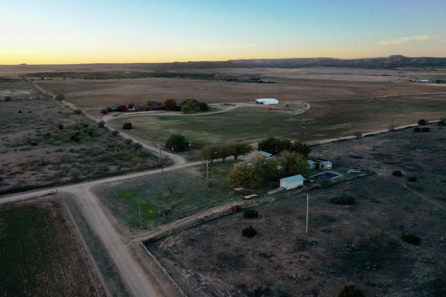 aerial view at dusk featuring a rural view