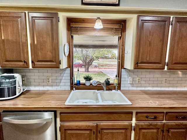 kitchen featuring wooden counters, dishwasher, sink, and decorative backsplash