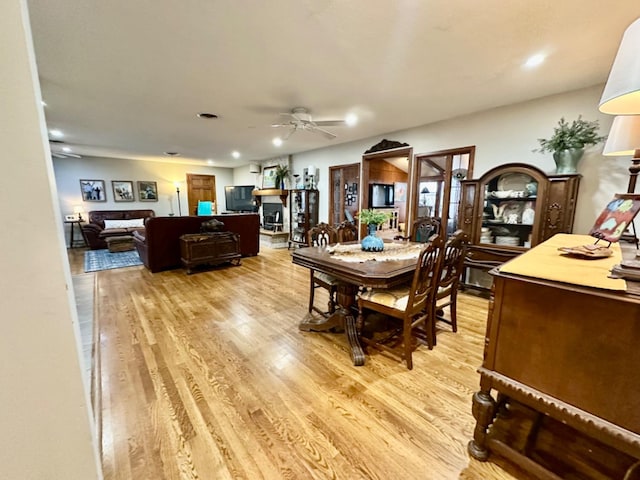 dining space featuring ceiling fan and light wood-type flooring