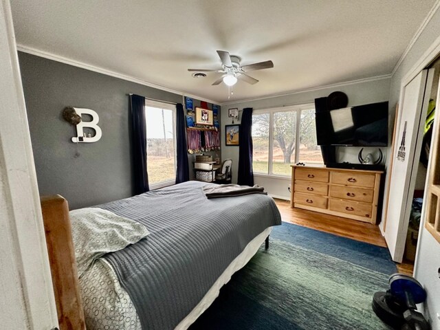 bedroom featuring multiple windows, crown molding, and dark hardwood / wood-style floors