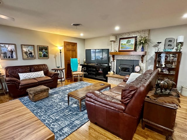 living room with a large fireplace and hardwood / wood-style floors