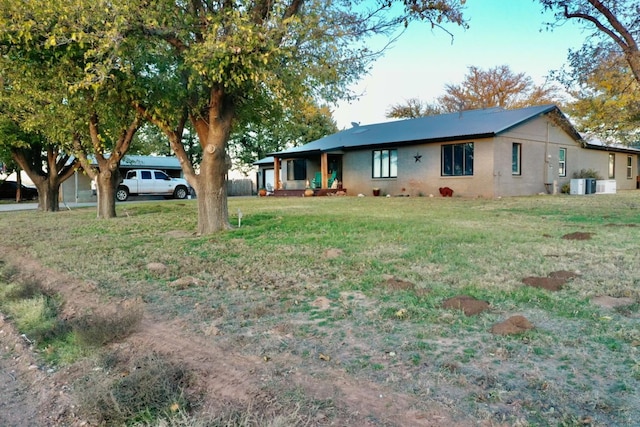 view of front of home featuring central AC unit and a front lawn