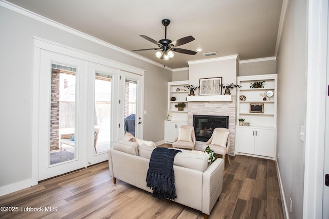 1308 Dover Ln, Wolfforth, TX 79382 - living area with ornamental molding, baseboards, a ceiling fan, a fireplace, and wood finished floors