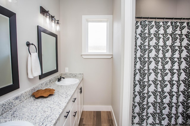 1308 Dover Ln, Wolfforth, TX 79382 - full bathroom featuring vanity, wood finished floors, baseboards, and curtained shower