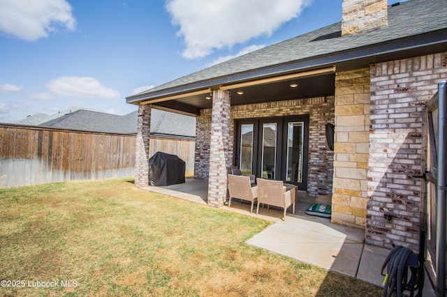 1308 Dover Ln, Wolfforth, TX 79382 - back of property featuring brick siding, a patio area, roof with shingles, and a chimney