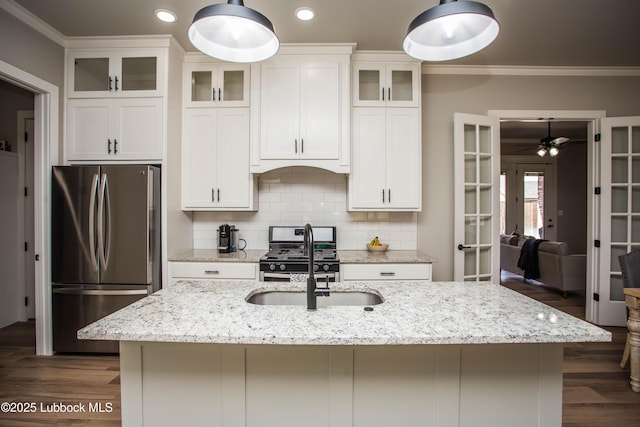 1308 Dover Ln, Wolfforth, TX 79382 - kitchen with appliances with stainless steel finishes, french doors, an island with sink, white cabinets, and crown molding