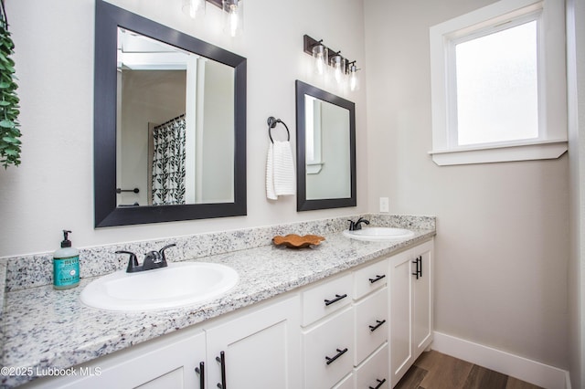 1308 Dover Ln, Wolfforth, TX 79382 - bathroom with double vanity, baseboards, and wood finished floors