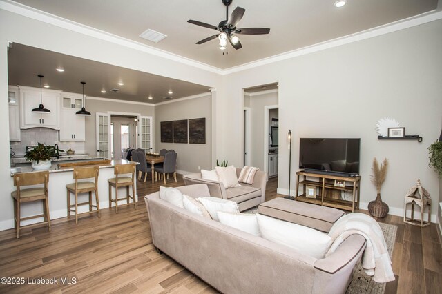 1308 Dover Ln, Wolfforth, TX 79382 - living area with ceiling fan, light wood-style flooring, recessed lighting, ornamental molding, and baseboards