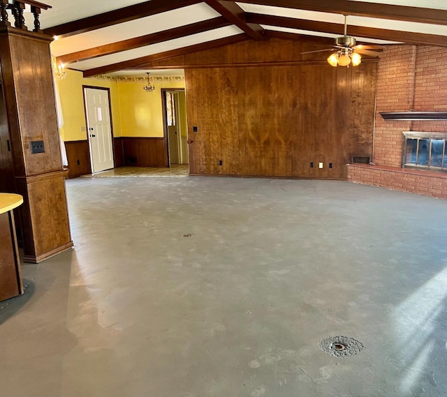 unfurnished living room with a brick fireplace, vaulted ceiling with beams, concrete floors, and wooden walls