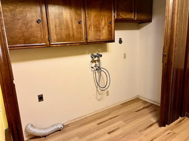 washroom featuring cabinets, washer hookup, hookup for an electric dryer, and light wood-type flooring