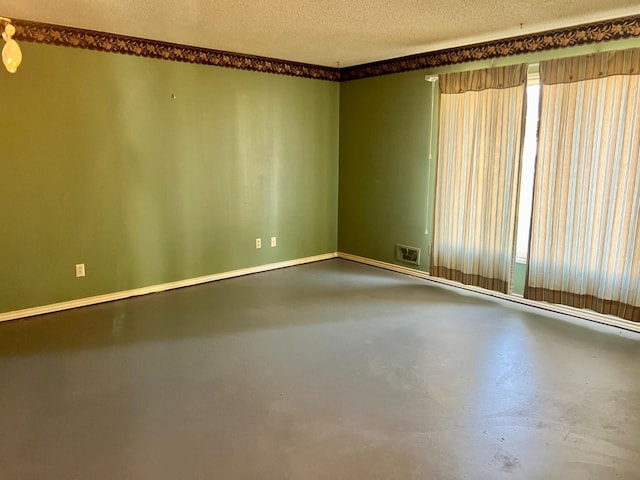 spare room with concrete floors and a textured ceiling