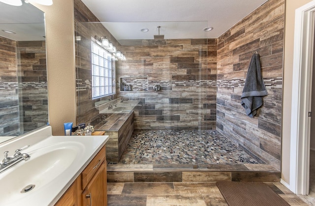 bathroom with vanity and a tile shower