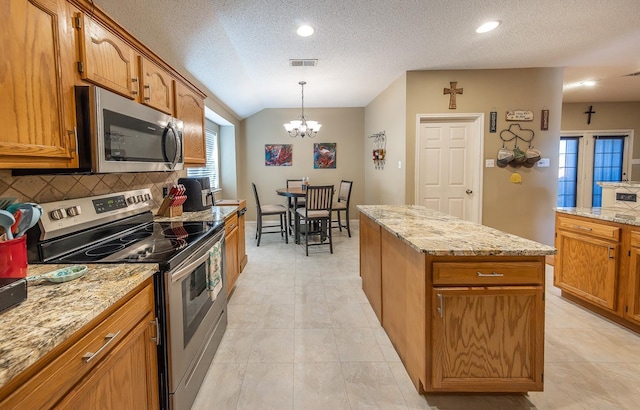 kitchen with appliances with stainless steel finishes, decorative light fixtures, a chandelier, decorative backsplash, and a textured ceiling