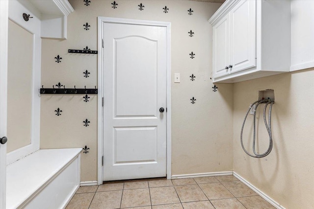 washroom with cabinets, washer hookup, and light tile patterned floors