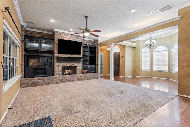 unfurnished living room featuring a brick fireplace, ornamental molding, hardwood / wood-style floors, and a textured ceiling