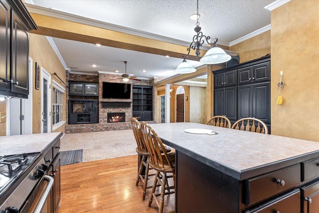 kitchen featuring ornamental molding, a center island, a kitchen bar, and decorative light fixtures