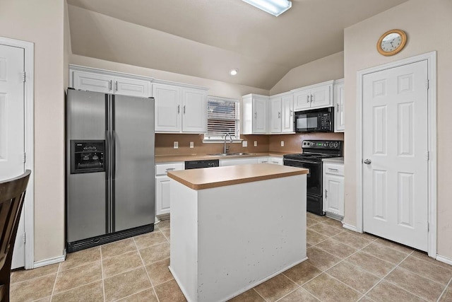 kitchen featuring light tile patterned flooring, sink, black appliances, a kitchen island, and white cabinets