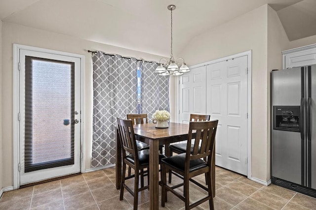 dining area with lofted ceiling, tile patterned flooring, and a notable chandelier