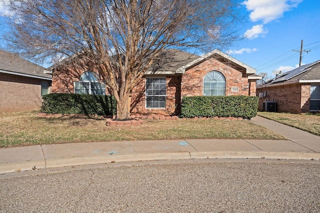 view of front of property with a front lawn and central air condition unit