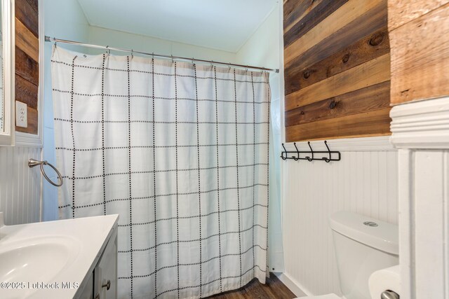5320 25th St, Lubbock, TX 79407 - full bathroom featuring vanity, toilet, wood walls, and a shower with curtain