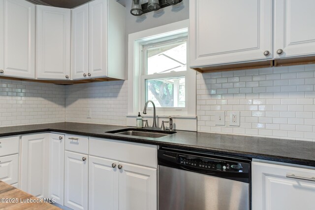 5320 25th St, Lubbock, TX 79407 - kitchen with dishwasher, a sink, dark countertops, and white cabinetry