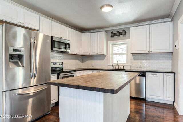 5320 25th St, Lubbock, TX 79407 - kitchen featuring appliances with stainless steel finishes, a sink, wooden counters, white cabinetry, and backsplash