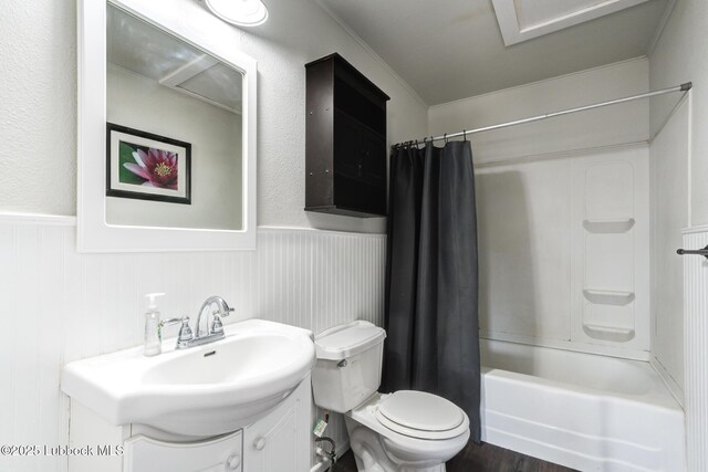 5320 25th St, Lubbock, TX 79407 - full bathroom featuring a wainscoted wall, vanity, shower / bath combination with curtain, toilet, and wood finished floors