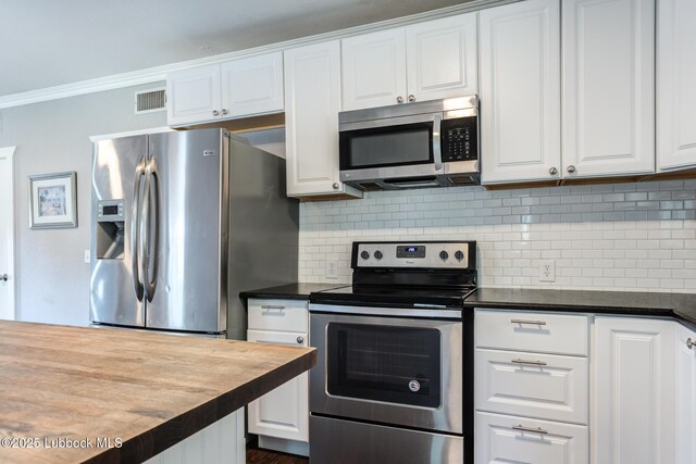 5320 25th St, Lubbock, TX 79407 - kitchen with stainless steel appliances, white cabinetry, tasteful backsplash, crown molding, and wooden counters