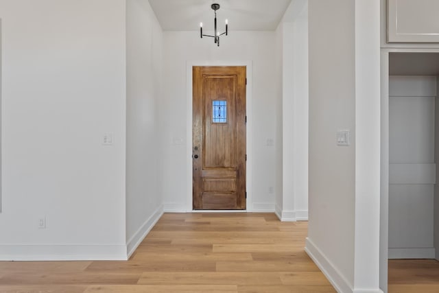 foyer entrance with an inviting chandelier and light wood-type flooring