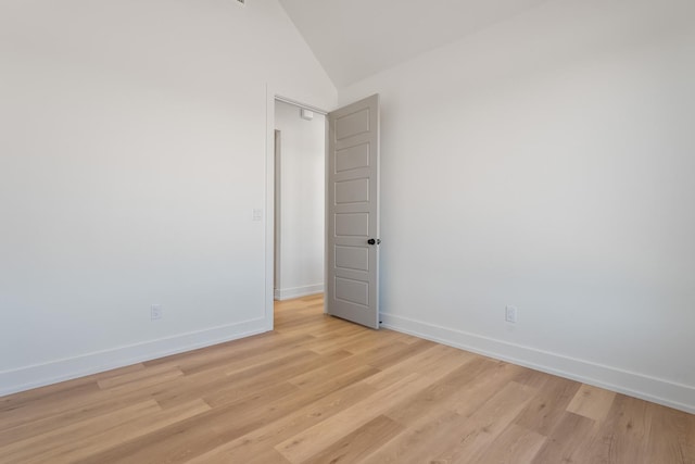 unfurnished room featuring vaulted ceiling and light hardwood / wood-style floors