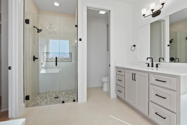 bathroom with tile patterned flooring, vanity, a shower with shower door, and toilet