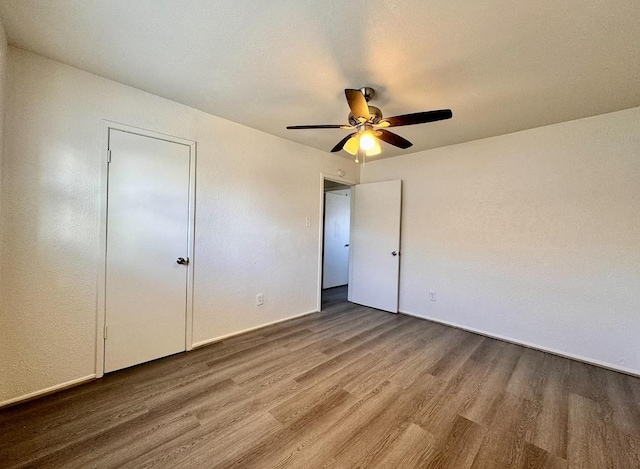 unfurnished bedroom with ceiling fan and wood-type flooring