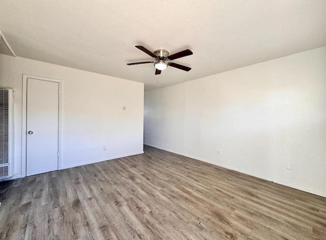 unfurnished room featuring ceiling fan, hardwood / wood-style floors, and a textured ceiling