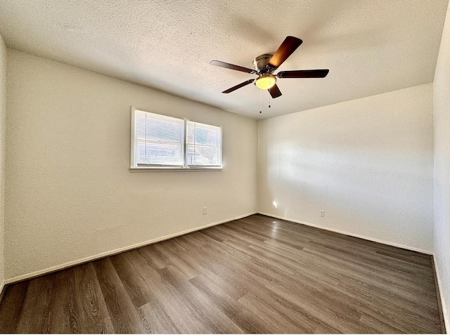 empty room with ceiling fan, wood-type flooring, and a textured ceiling