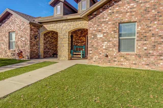 entrance to property featuring a lawn