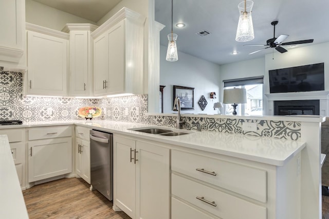 kitchen with white cabinetry, tasteful backsplash, sink, and hanging light fixtures