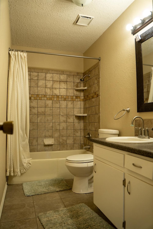 full bathroom featuring shower / bath combination with curtain, vanity, toilet, tile patterned floors, and a textured ceiling