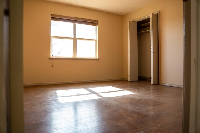 unfurnished bedroom with a closet, a textured ceiling, and light wood-type flooring