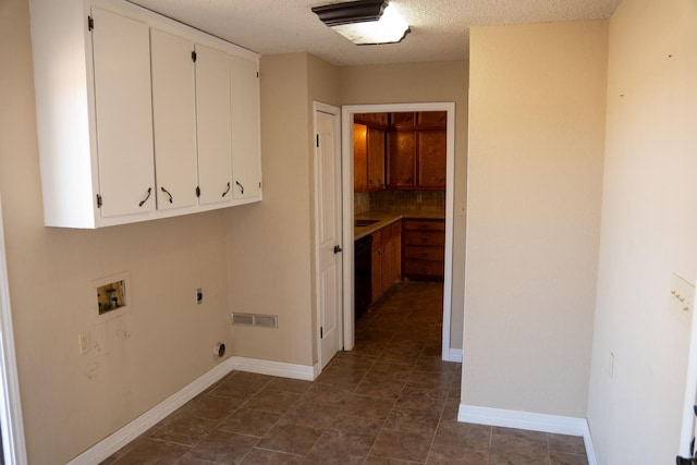 laundry area featuring cabinets, washer hookup, hookup for an electric dryer, and a textured ceiling