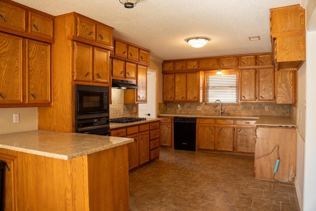 kitchen featuring sink, tasteful backsplash, black appliances, a textured ceiling, and kitchen peninsula