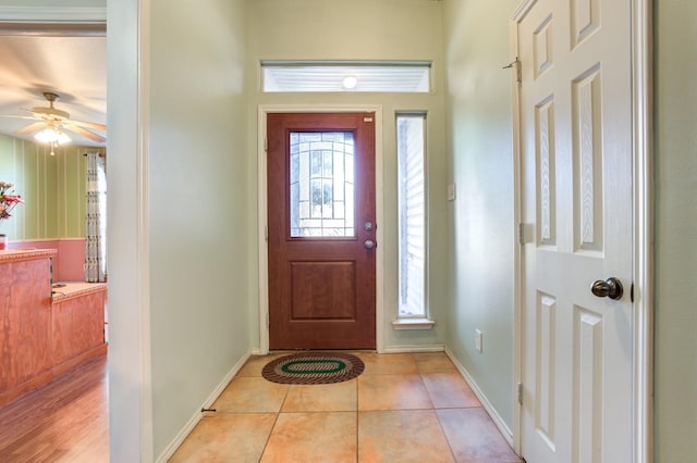 entrance foyer with light tile patterned floors, a wealth of natural light, and ceiling fan