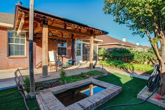 back of house with a jacuzzi, a patio area, and a lawn