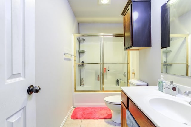 full bathroom with toilet, tile patterned floors, bath / shower combo with glass door, and vanity