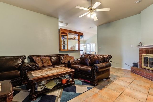 living room featuring ceiling fan, a fireplace, and light tile patterned floors