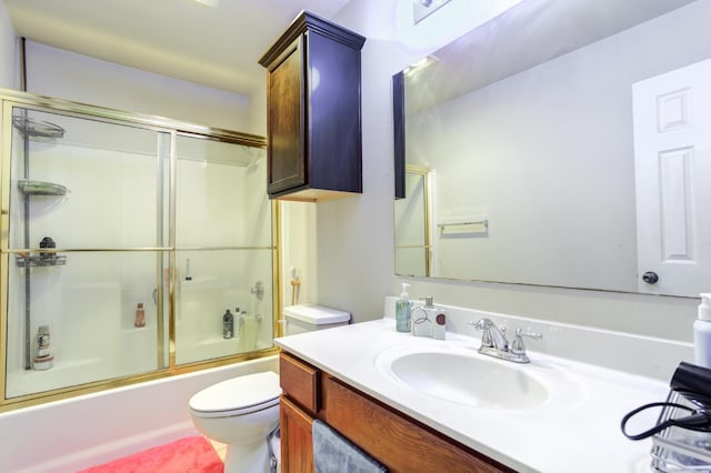 full bathroom featuring enclosed tub / shower combo, vanity, and toilet